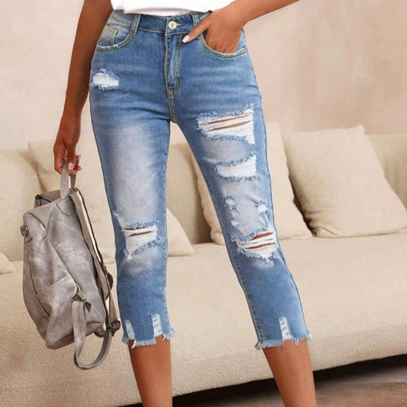 Dammjeans med sliten look, revor och råkant