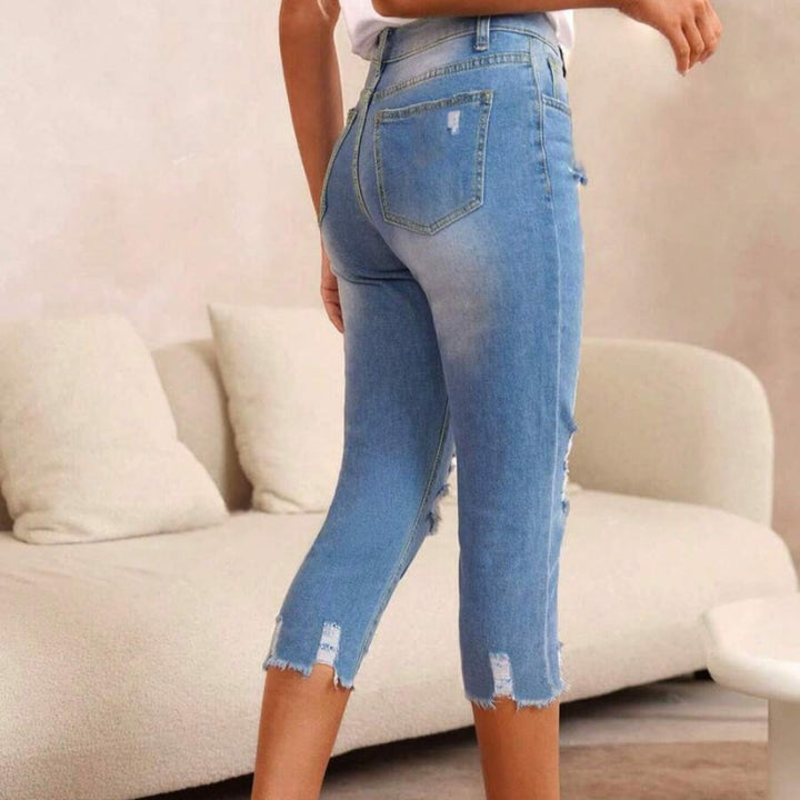 Dammjeans med sliten look, revor och råkant